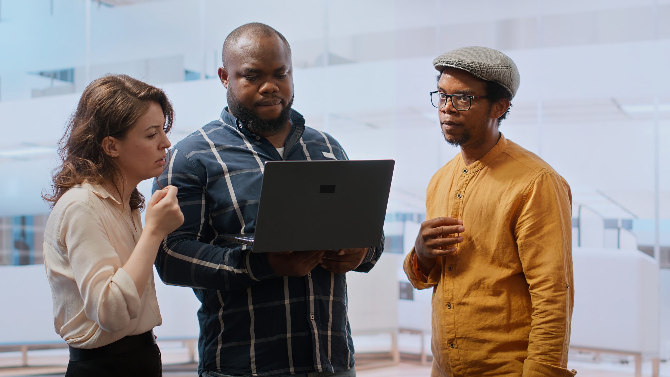 Real estate agent presenting a new office building to clients, discussing the detailed blueprints using a tablet during the property tour. Potential leasing investment opportunity. Camera B.